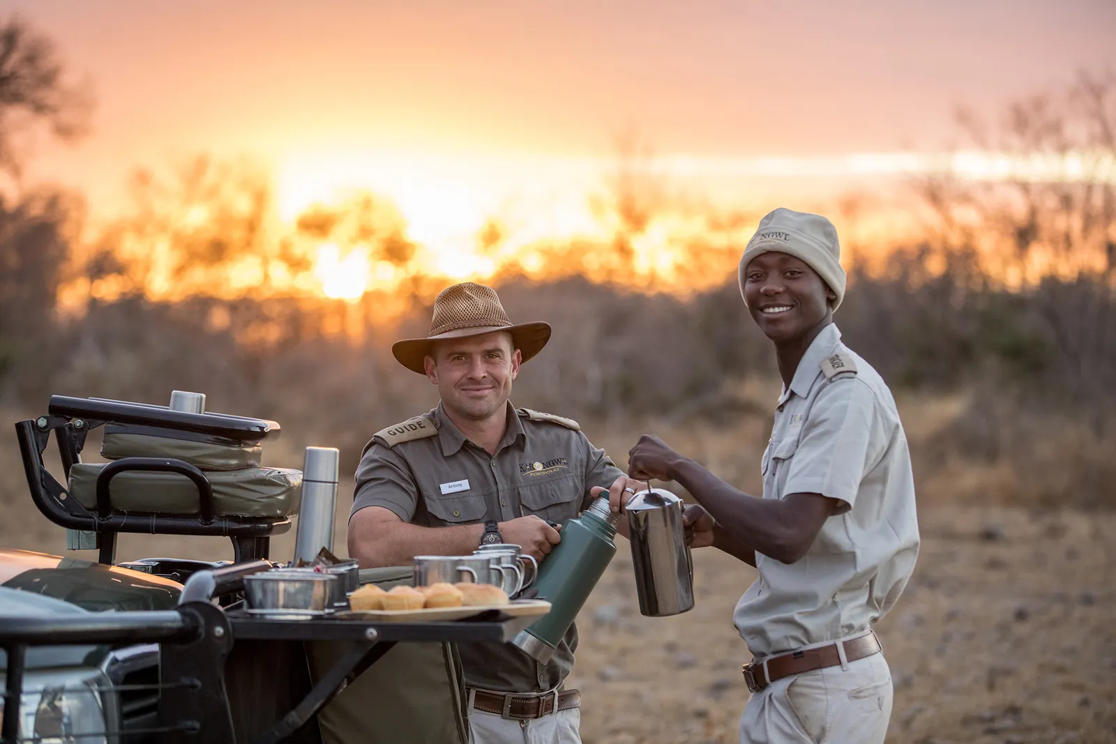 Karongwe guides preparing refreshments beside a safari vehicle at sunset