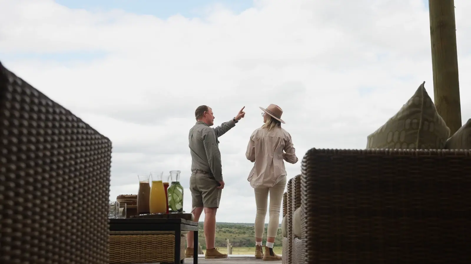 A safari guide and guest looking across the reserve from a lodge deck