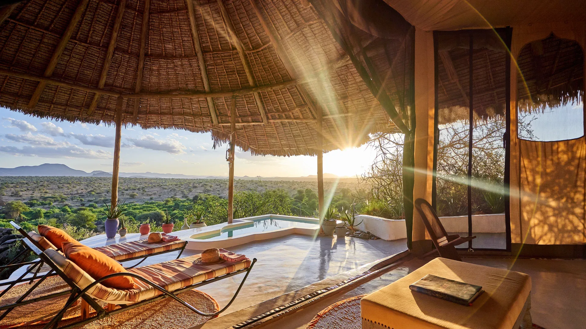Golden-hour view from a thatched Sasaab Lodge terrace with loungers, private pool and Samburu landscape.