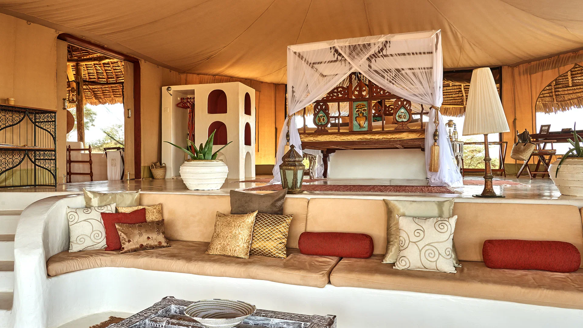 Canopied bed and sitting area inside a suite at Sasaab in Samburu