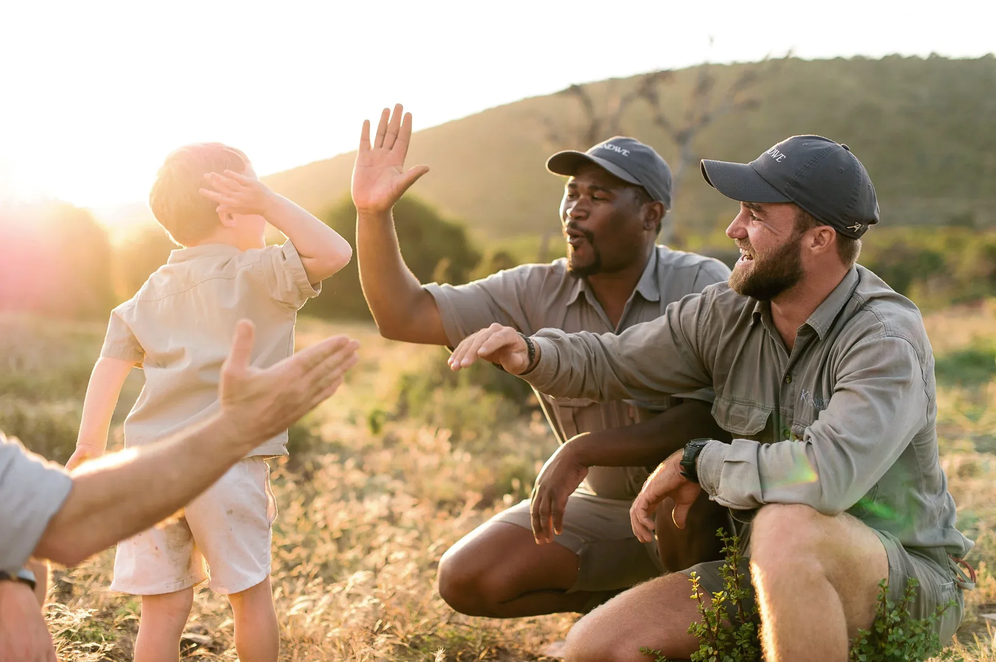Young child high-fiving safari guides at Kwandwe Private Game Reserve