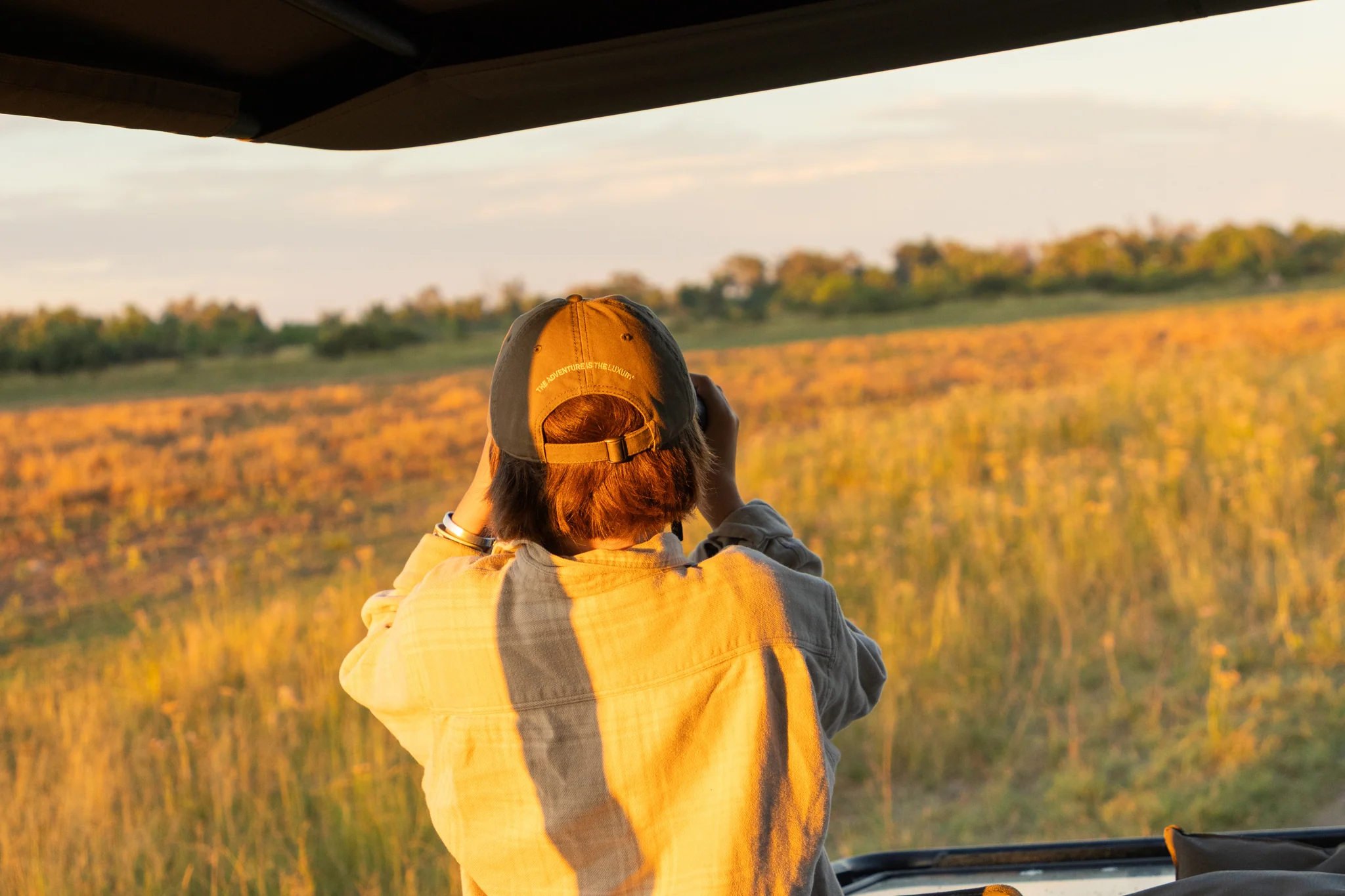 Traveller watching the South African bush from an open safari vehicle