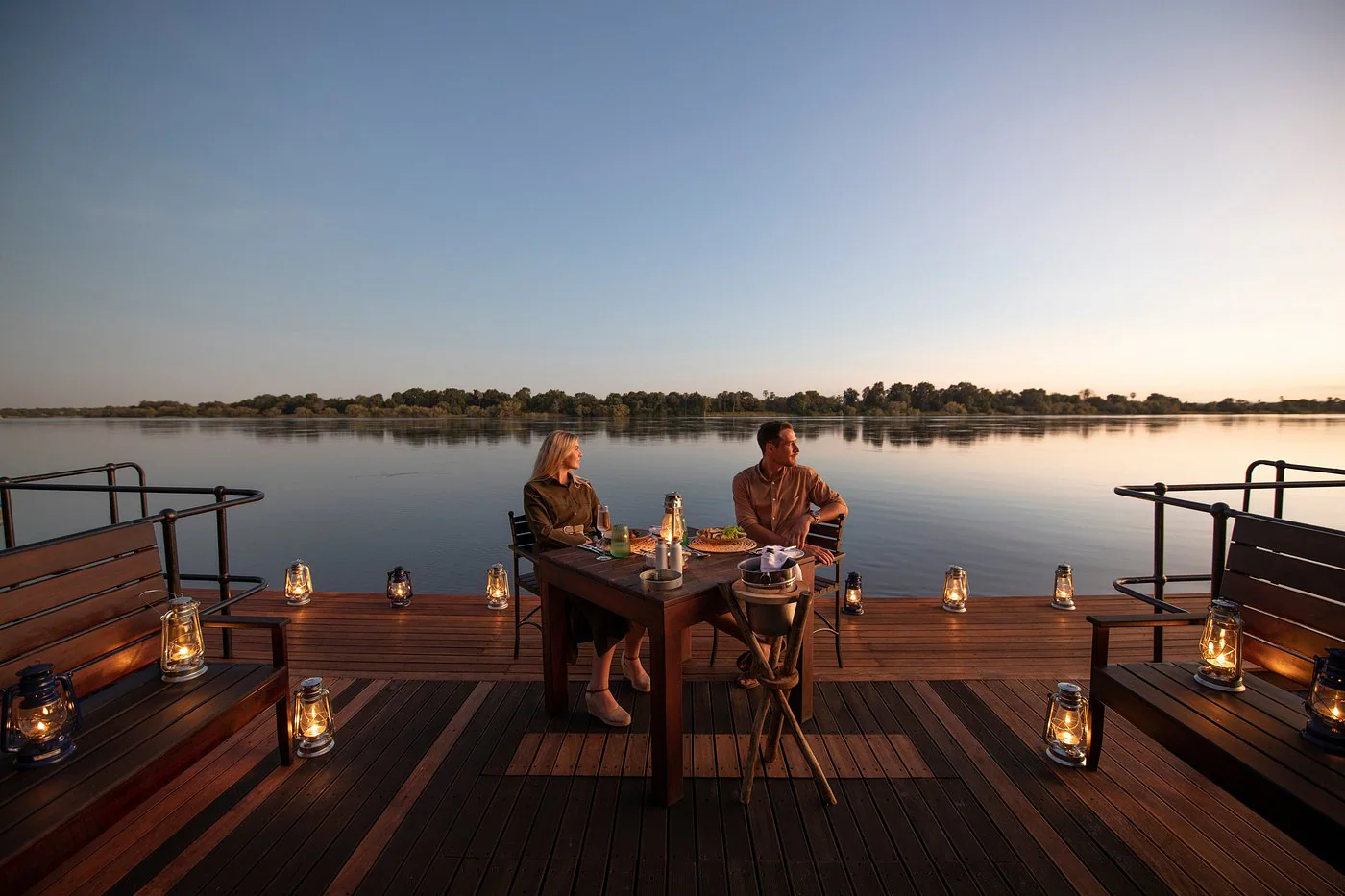 Couple dining beside the Zambezi River at Mukwa River Lodge in Livingstone, Zambia